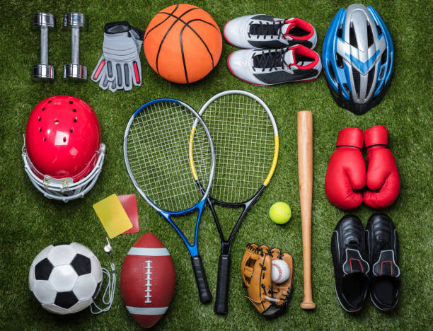 High Angle View Of Various Sport Equipments On Green Grass